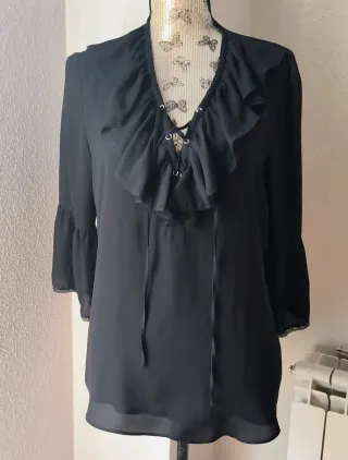 Blusa negra con volantes y cordones