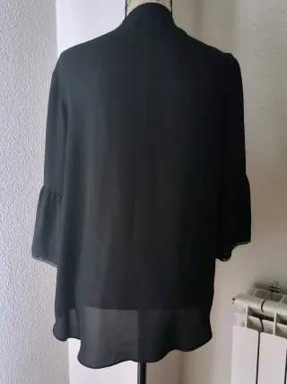 Blusa negra con volantes y cordones