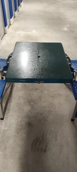 Mesa plegable con sillas de camping.