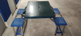 Mesa plegable con sillas de camping.