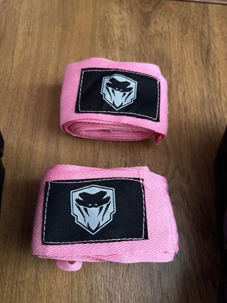 Set de guantes de boxeo negros y vendas rosas.