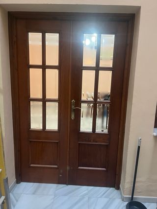 Puerta doble madera con cristales.