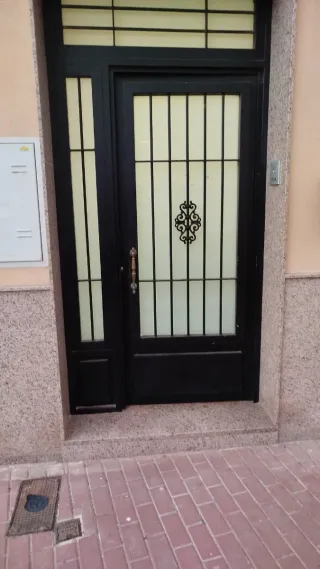 Puerta de entrada negra con rejas