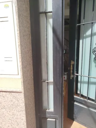 Puerta de entrada negra con rejas