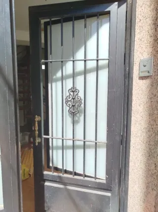 Puerta de entrada negra con rejas