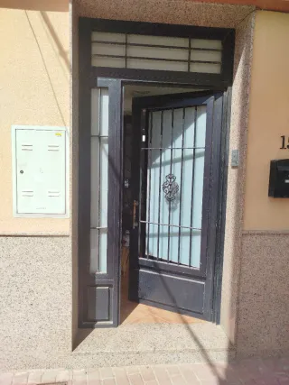 Puerta de entrada negra con rejas