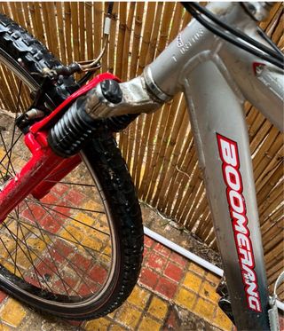 Bicicleta de montaña plateada con horquilla roja