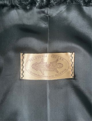 Abrigo negro de textura rizada tipo astracán.