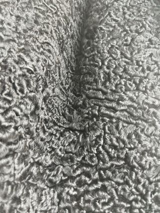 Abrigo negro de textura rizada tipo astracán.