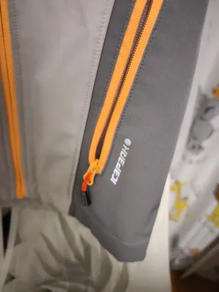 Cortavientos gris y naranja con capucha