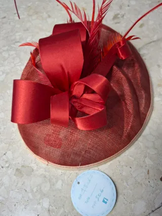 Tocado rojo con lazo y plumas