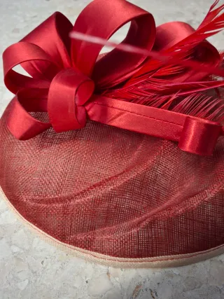 Tocado rojo con lazo y plumas