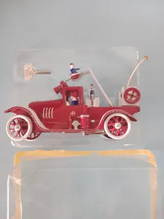 Macchina di latta rossa con figure