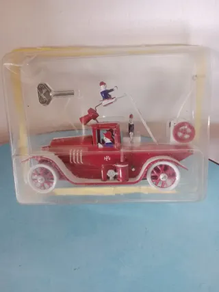 Macchina di latta rossa con figure