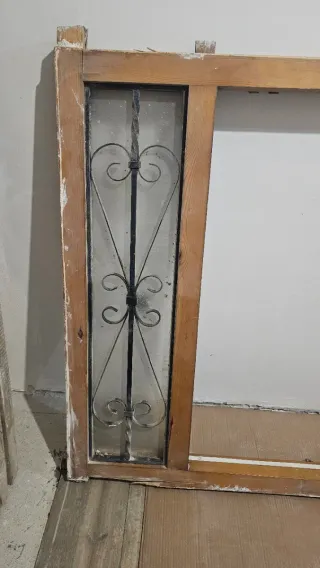 Puerta madera antigua con reja seguridad.
