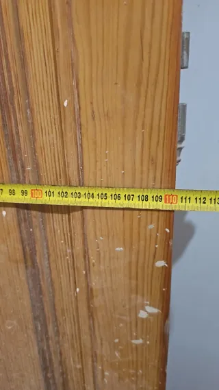 Puerta madera antigua con reja seguridad.