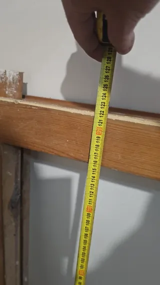 Puerta madera antigua con reja seguridad.