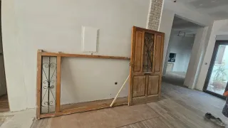 Puerta madera antigua con reja seguridad.