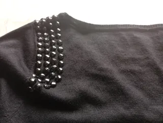 Suéter negro con pedrería en hombros