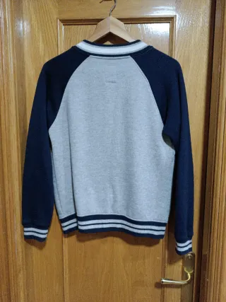 Chaqueta estilo béisbol gris y azul.