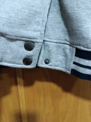 Chaqueta estilo béisbol gris y azul.