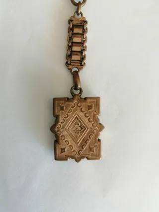 Antigua cadena de reloj con fob decorativo .