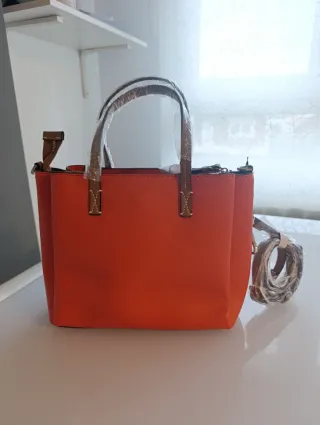 Bolso naranja y marrón (hombro y mano)