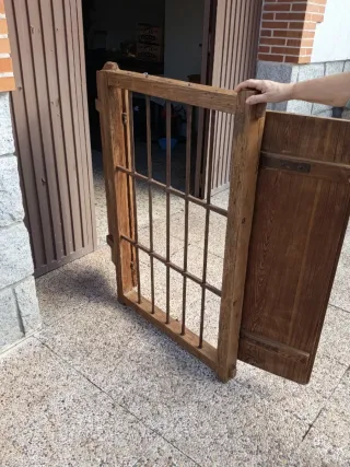 Ventana de madera antigua con reja de forja.