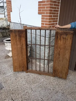 Ventana de madera antigua con reja de forja.