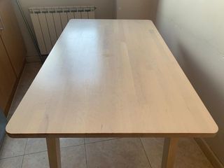 Mesa de cocina con taburetes y banqueta.