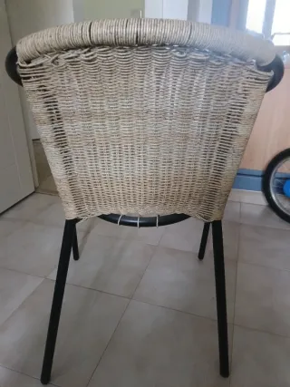 Silla de ratán natural con estructura metálica.