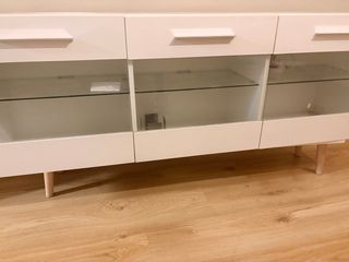 Mueble de salón blanco con puertas de cristal.