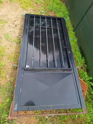 Puerta de hierro con rejas y contra ventana