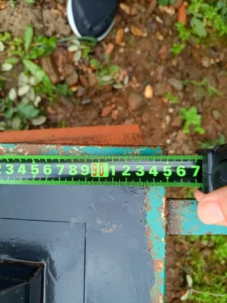 Puerta de hierro con rejas y contra ventana