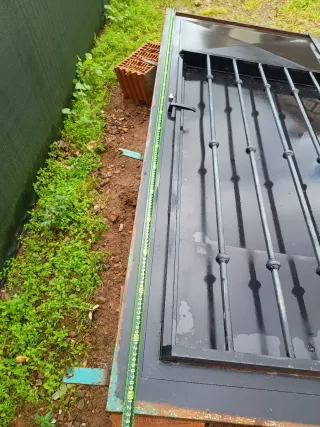 Puerta de hierro con rejas y contra ventana