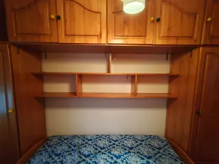 Habitación puente madera dos armarios y dos camas.