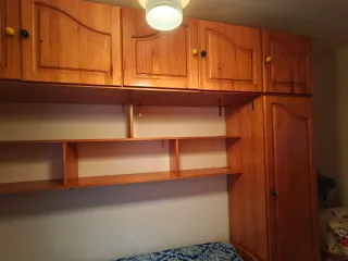 Habitación puente madera dos armarios y dos camas.