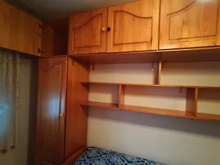 Habitación puente madera dos armarios y dos camas.