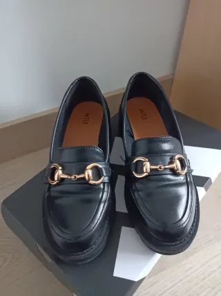 Mocasines negros con detalle dorado