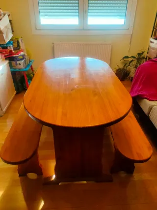 Mesa de madera con 2 bancos. Tienen marcas de uso.