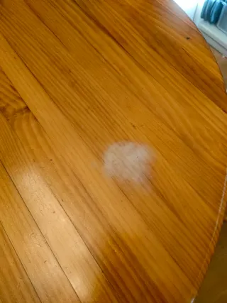 Mesa de madera con 2 bancos. Tienen marcas de uso.