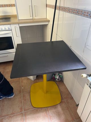 Mesa cuadrada negra y base amarilla metálica