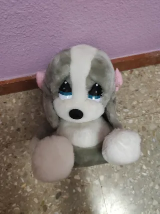 Peluche perro gris y blanco con lazos rosa.