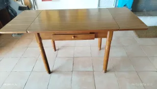 Mesa de cocina extensible de madera con dos alas.