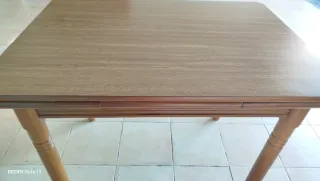Mesa de cocina extensible de madera con dos alas.