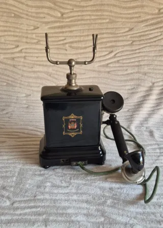 Teléfono antiguo negro con detalles dorados