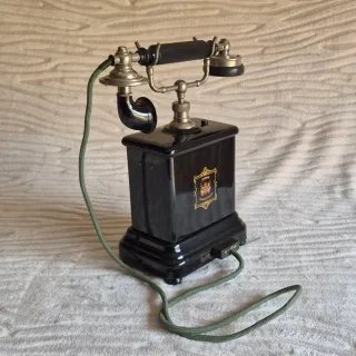 Teléfono antiguo negro con detalles dorados