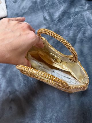Bolso de mano dorado con pedrería