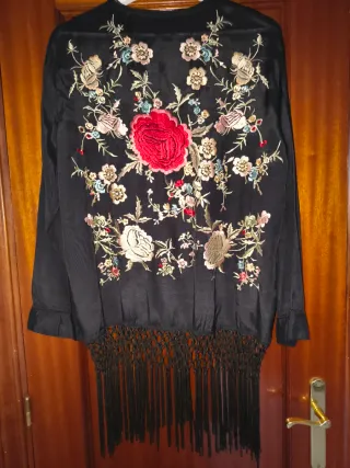 Chaqueta bordada negra con flecos.