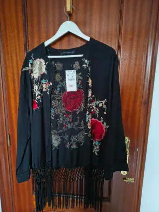 Chaqueta bordada negra con flecos.
